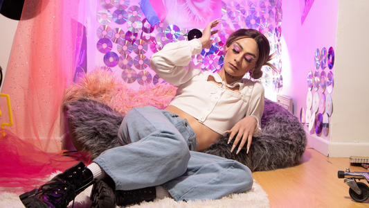Modella con outfit stile Y2K che indossa un crop top bianco a maniche lunghe, jeans baggy chiari e anfibi neri in vernice